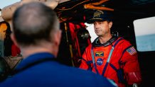 NASA astronaut Reid Wiseman talks to NASA personnel on the flight deck of the San Antonio Class amphibious transport dock USS John P. Murtha (LPD 26) after returning from space on Apr. 10, 2026. John P. Murtha is underway in the U.S. 3rd Fleet area of operations supporting NASA’s Artemis II mission, retrieving the crew and spacecraft following their return to Earth and splashdown in the Pacific Ocean. NASA’s Artemis II mission sent four astronauts on a flight around the moon in the Orion space craft, ma