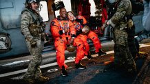 NASA astronauts Victor Glover, left, and Christina Koch sit in an U.S. Navy MH-60S Seahawk attached to Helicopter Sea Combat Squadron (HSC) 23 on the flight deck of the San Antonio Class amphibious transport dock USS John P. Murtha (LPD 26) after returning from space on Apr. 10, 2026. John P. Murtha is underway in the U.S. 3rd Fleet area of operations supporting NASA’s Artemis II mission, retrieving the crew and spacecraft following their return to Earth and splashdown in the Pacific Ocean. NASA’s Artem