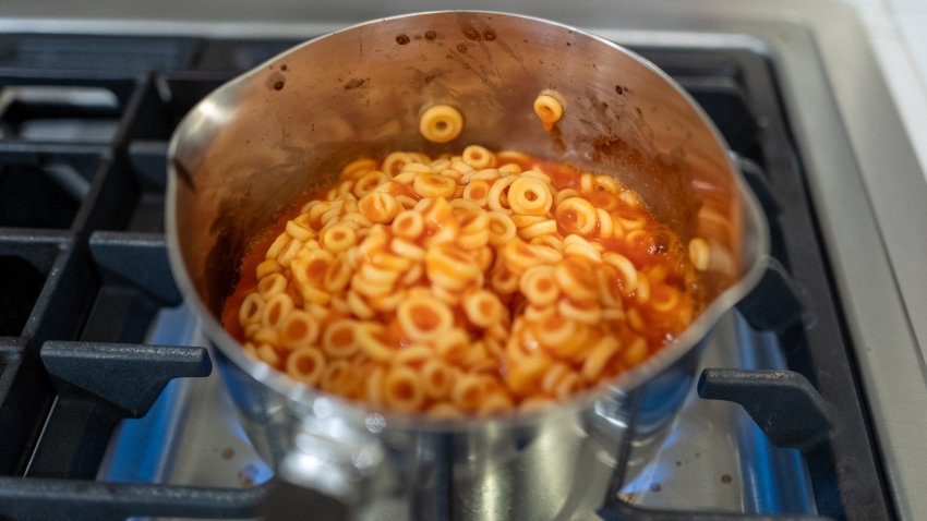 SpaghettiOs pasta cooking in a pot.