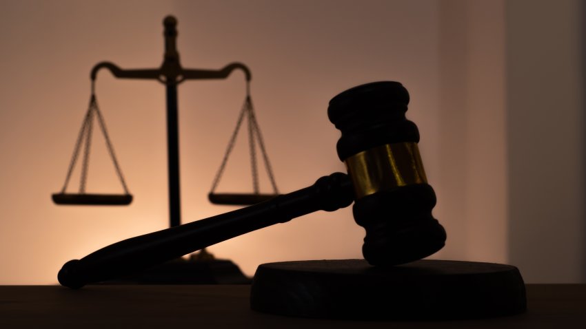 Siluetas de un mazo de juez y de la balanza de la justicia.