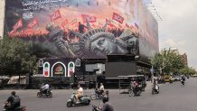 Iranians drive past an anti-US billboard at Enghelab Square in central Tehran on August 3, 2026. Iran denied any negotiations were taking place with the United States after the US president said new talks would begin on August 3 in an effort to end their war, now in its sixth month. Washington and Tehran have been at war since February 28, when the US and Israel launched surprise strikes against Iran, though months of on-off diplomacy have led to periods of relative calm. (Photo by ATTA KENARE / AFP via Getty Images) /