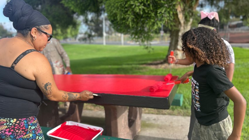 Jackie Del Rio (left) volunteered with two of her children, Sunday, painting picnic tables, San Diego, Calif., August 30, 2026.