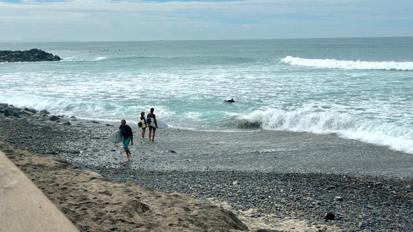 Surfers make their way over jagged stones, Saturday, after severe erosion washed away a portion of Tamarack State Beach, Carlsbad, Calif., September 5, 2026.