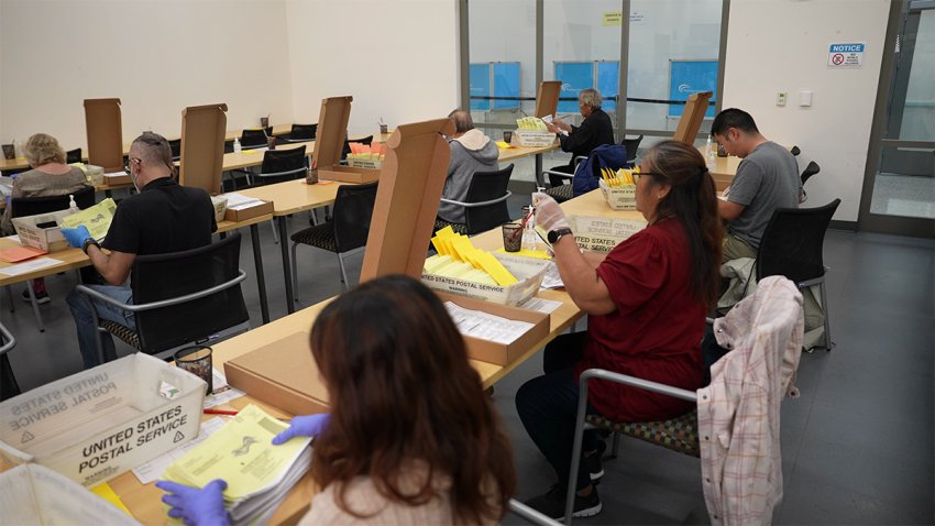 Election workers at the San Diego County Registrar's Office open up mail-in ballots after their signatures were verified.